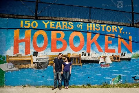 engaged couple in front of Hoboken mural during their Hoboken engagement session