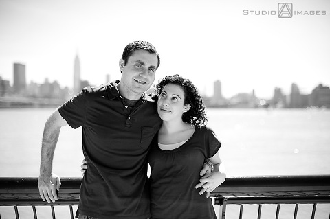 engaged couple in front of NYC skyline during their Hoboken engagement session