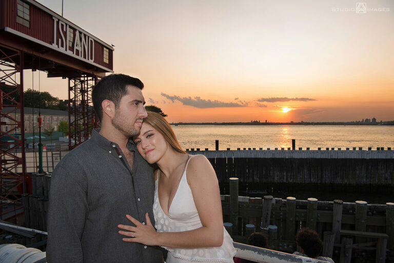 couple posing for their engagement photos at Governors Island at sunset