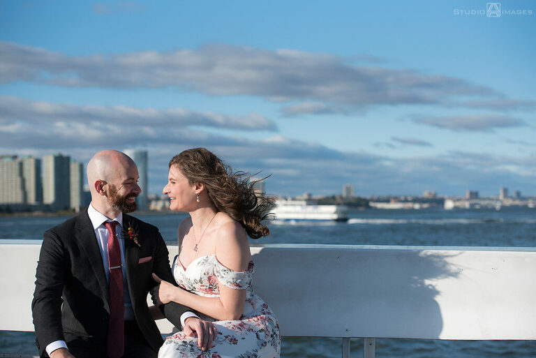 bride and groom posing for portraits on the ferry before their wedding at Liberty House in Jersey City