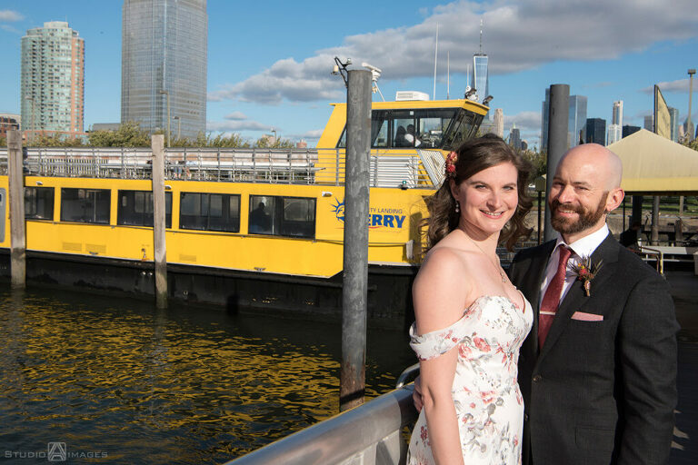 bride and groom posing for portraits with the ferry before their wedding at Liberty House in Jersey City