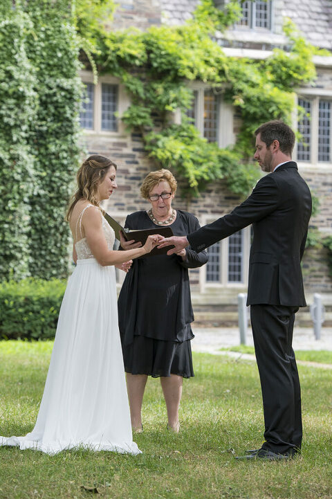 intimate wedding at Princeton University. Bride and groom exchange rings during ceremony