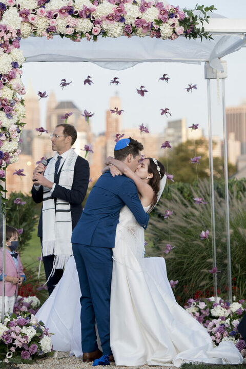 bride and groom kiss at conclusion of Jewish wedding ceremony at Liberty House in Jersey City