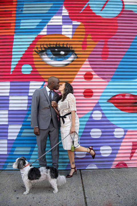 wedding couple kissing with their dog in front of mural in Welling Court