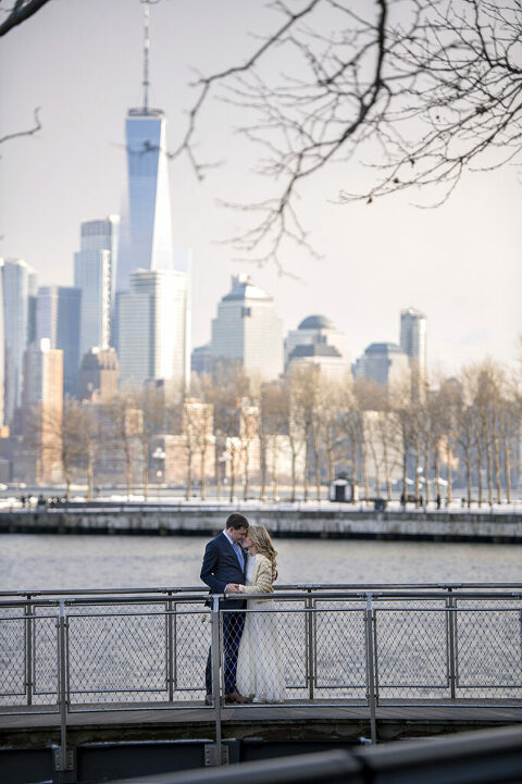 bride and groom in Hoboken on their wedding day with NYC skyline behind them