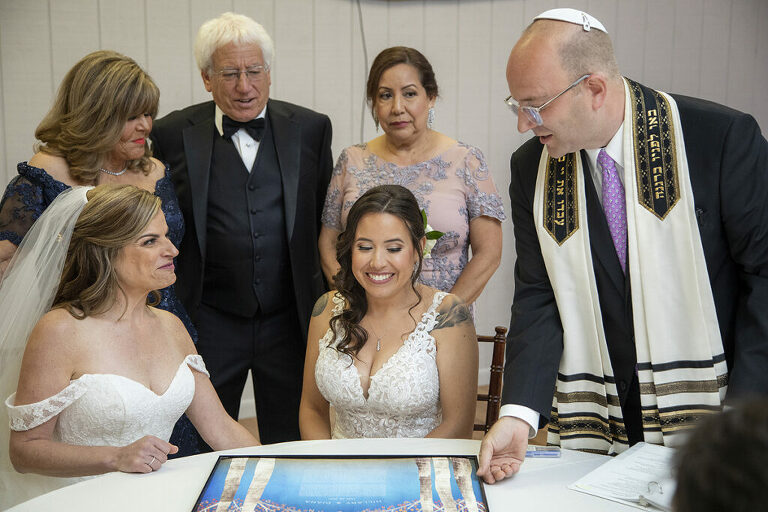 brides signing ketubah on wedding day at Windows on the Water at Frogbridge. LGBTQ wedding