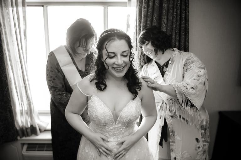 bride getting into her dress on wedding day at Conservatory at The Madison Hotel Wedding in Morristown, NJ