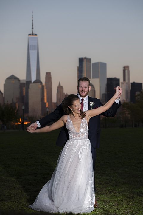 bride and groom with NYC skyline at Liberty House in Jersey City on their wedding day