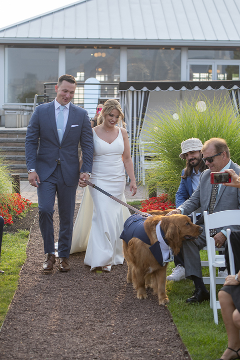 bride and groom walking down the aisle with their dog on wedding day at Liberty House in Jersey City