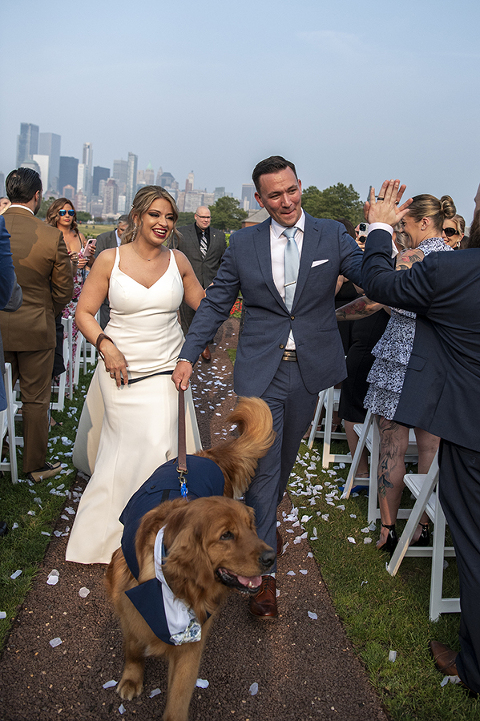 bride and groom walking down the aisle with their dog on wedding day at Liberty House in Jersey City