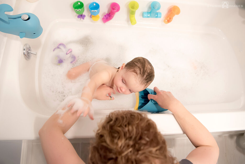 parents and daughter at bath time during their Documentary-style day in the life family photo shoot