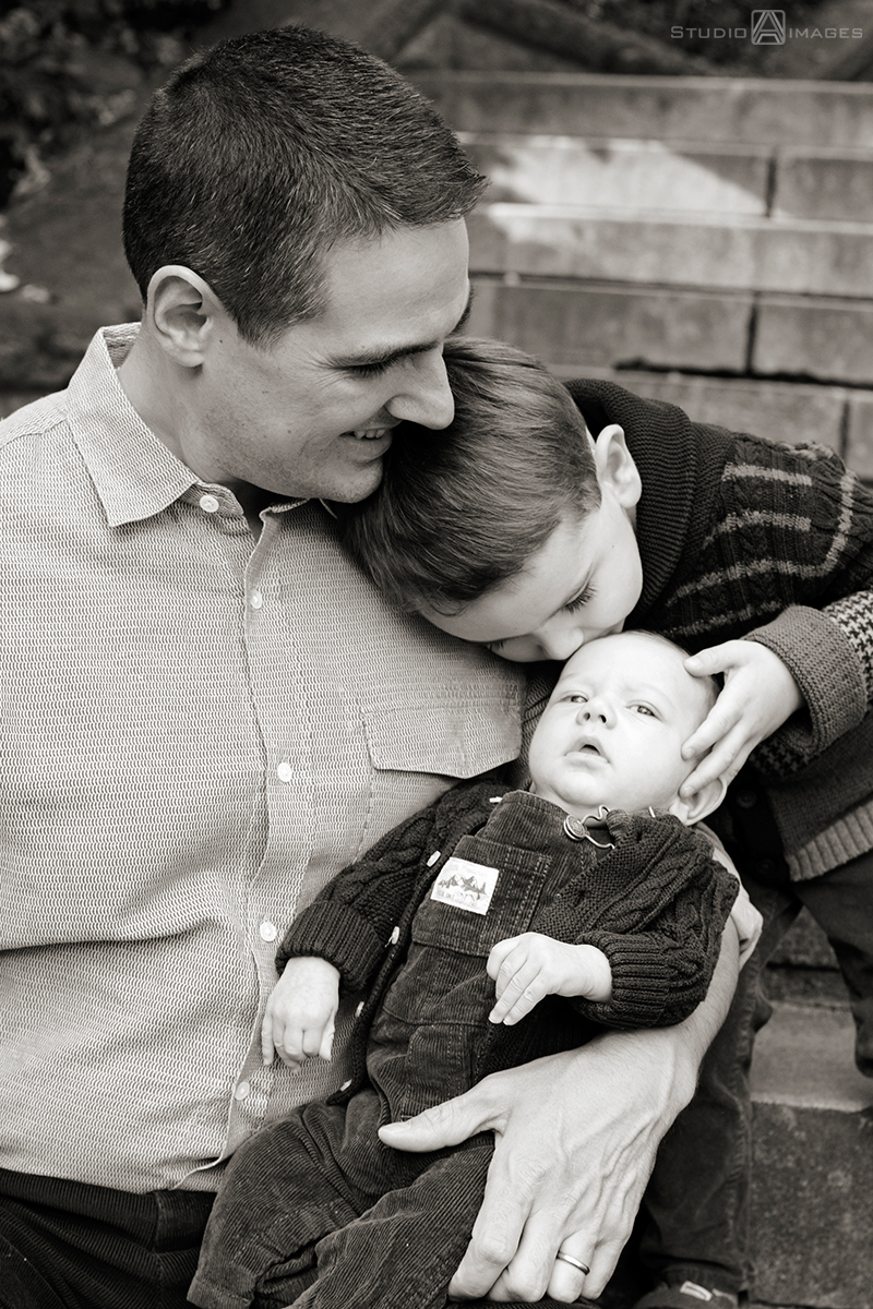 father and sons posing for portraits at Carl Schurz Park