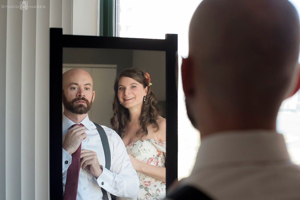 bride and groom getting ready for their wedding in their apt in Jersey City
