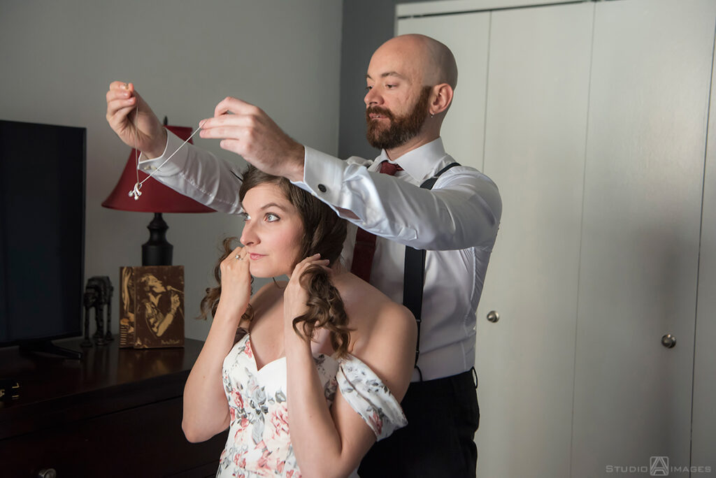 bride and groom getting ready for their wedding in their apt in Jersey City