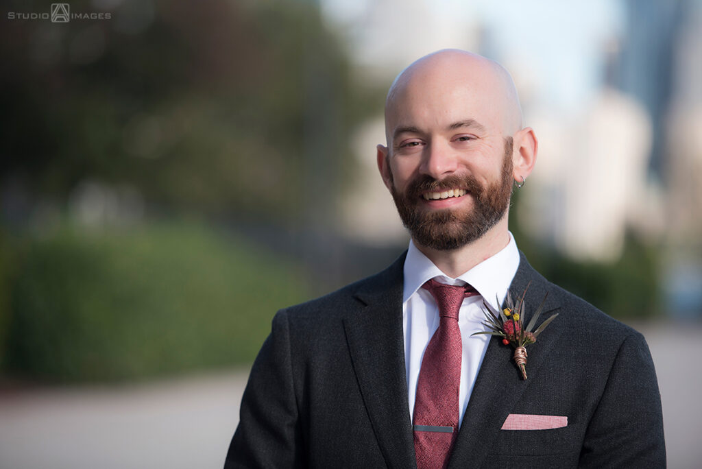 groom posing for portraits before their wedding at Liberty House in Jersey City