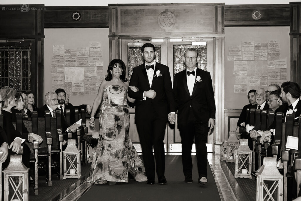 groom walking down the aisle with parents for wedding ceremony at Temple Emanu-El of Closter