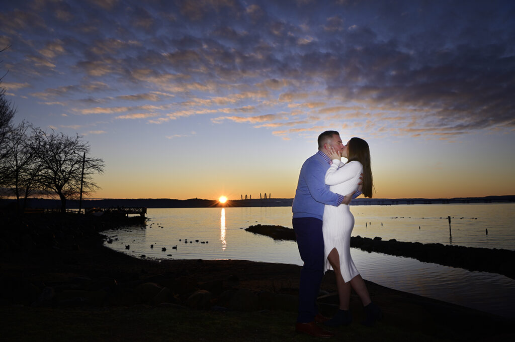 couple kissing against beautiful sunrise in Nyack during their engagement session