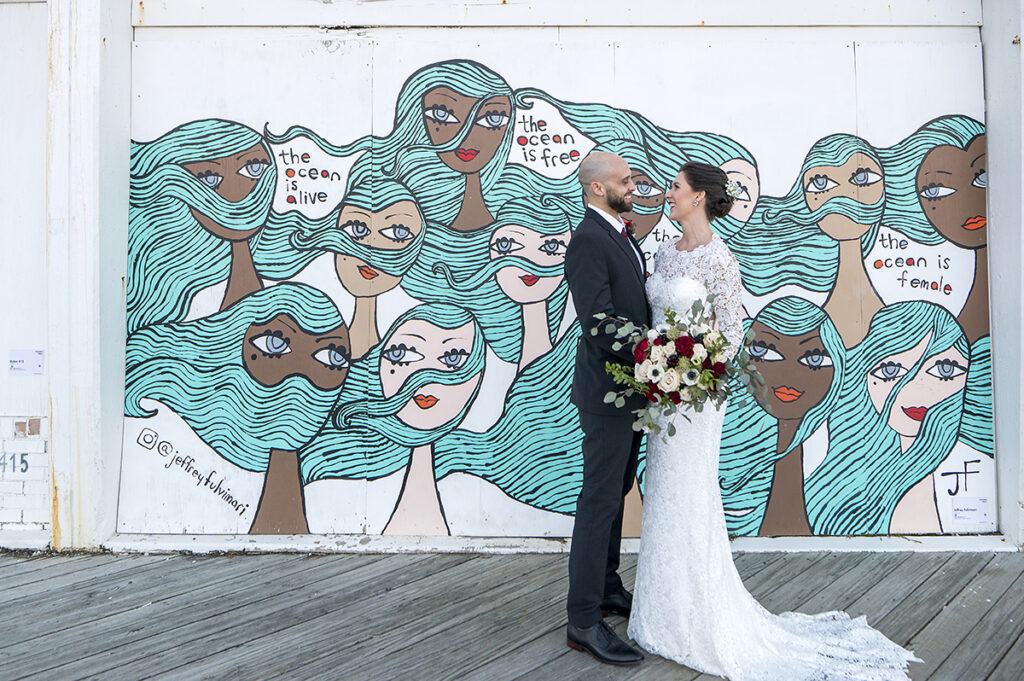 bride and groom in front of Asbury Park murals on their wedding day in Asbury Park.