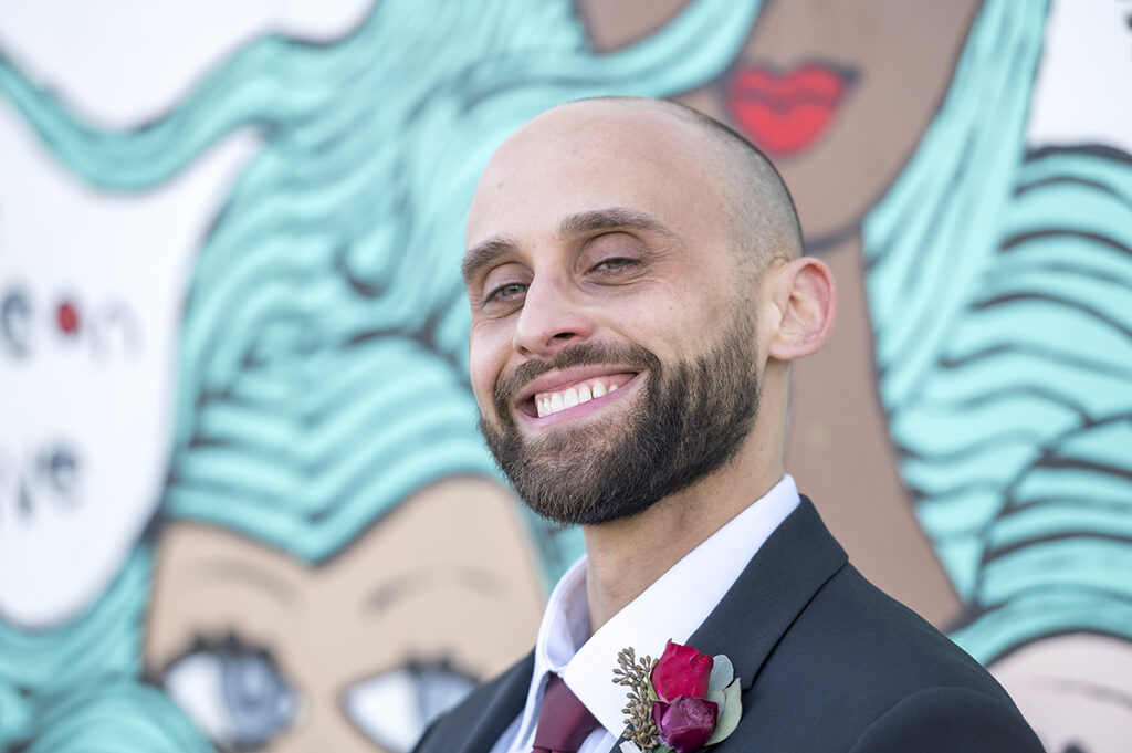 groom in front of Asbury Park murals on their wedding day in Asbury Park.