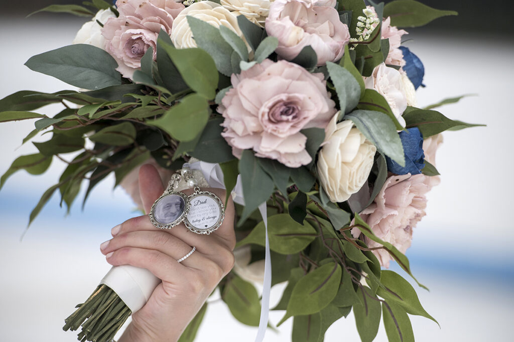 bride has a charm on her wedding bouquet to honor her late father