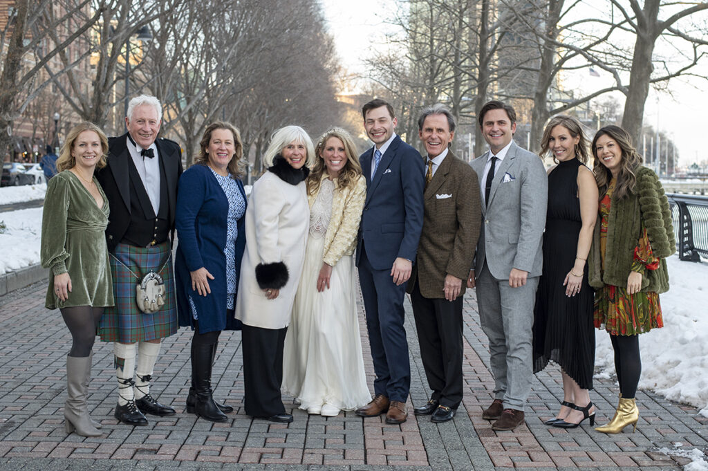 family and friends gather for a group photo along the Hoboken waterfront before the wedding ceremony