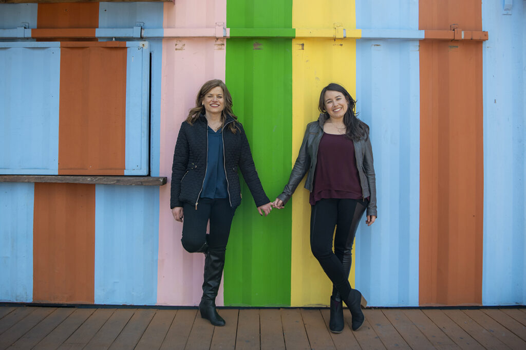 LGBTQ couple against colorful wall during their Philadelphia Engagement Session