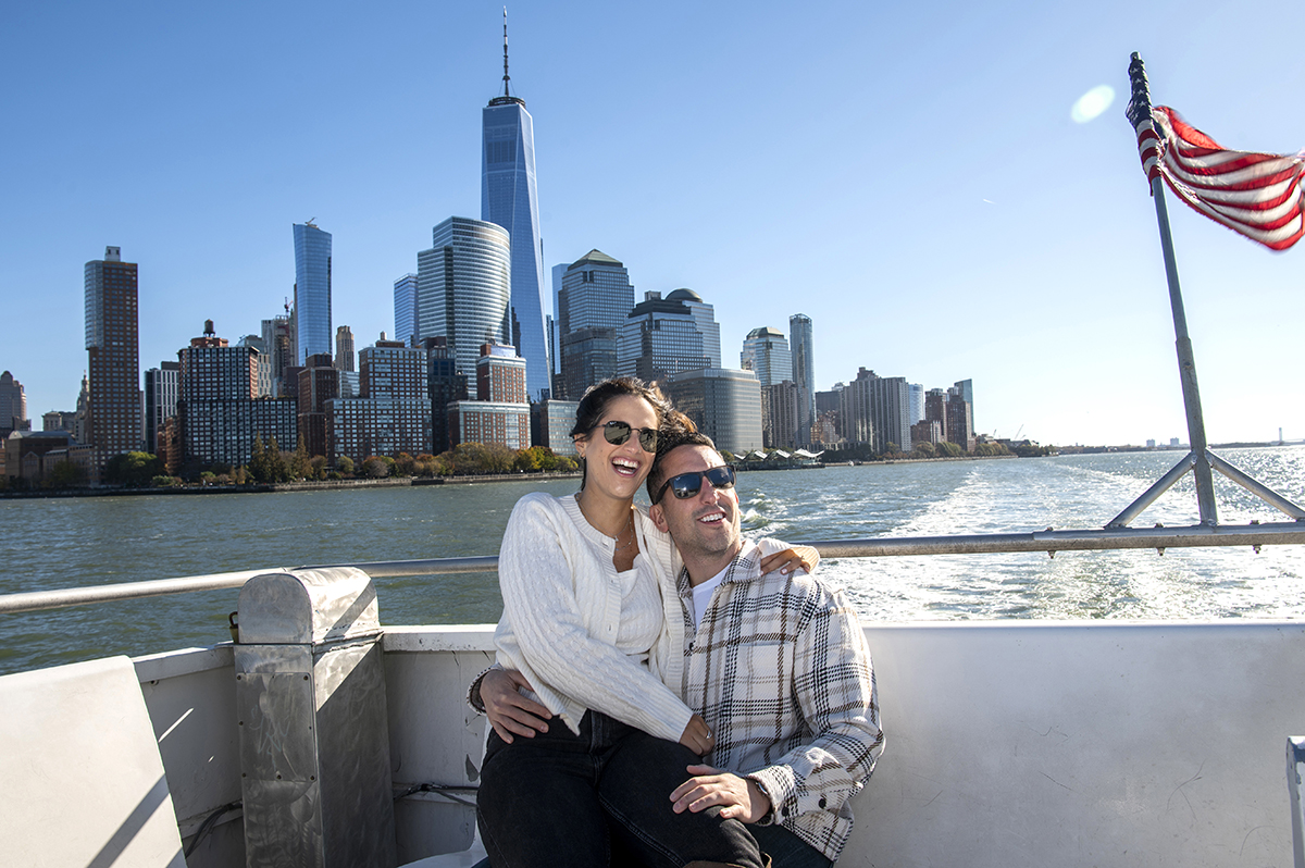 NYC engaged couple on ferry with NYC skyline
