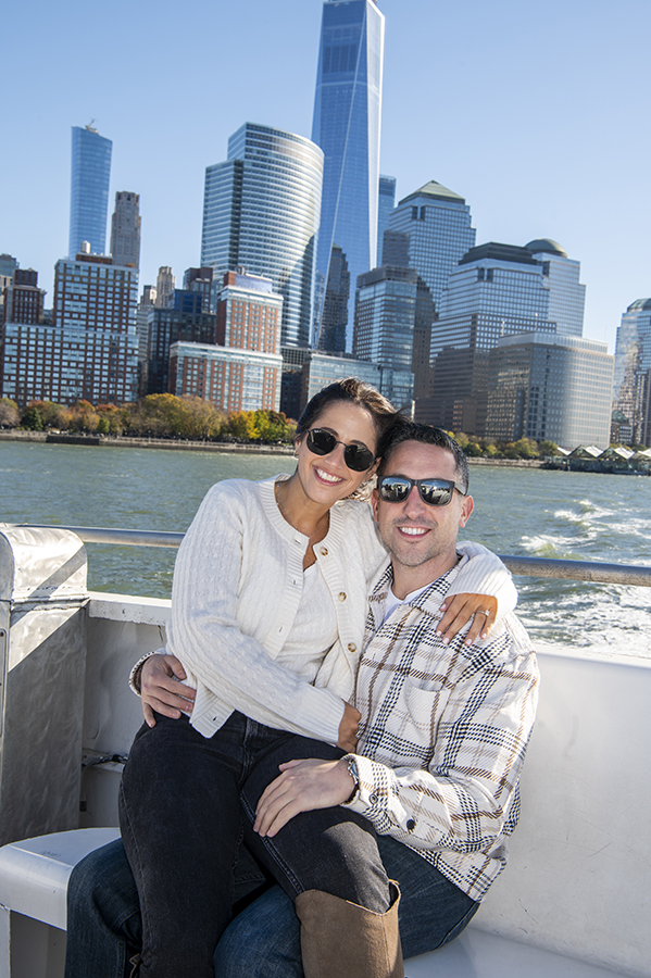 NYC engaged couple on ferry with NYC skyline