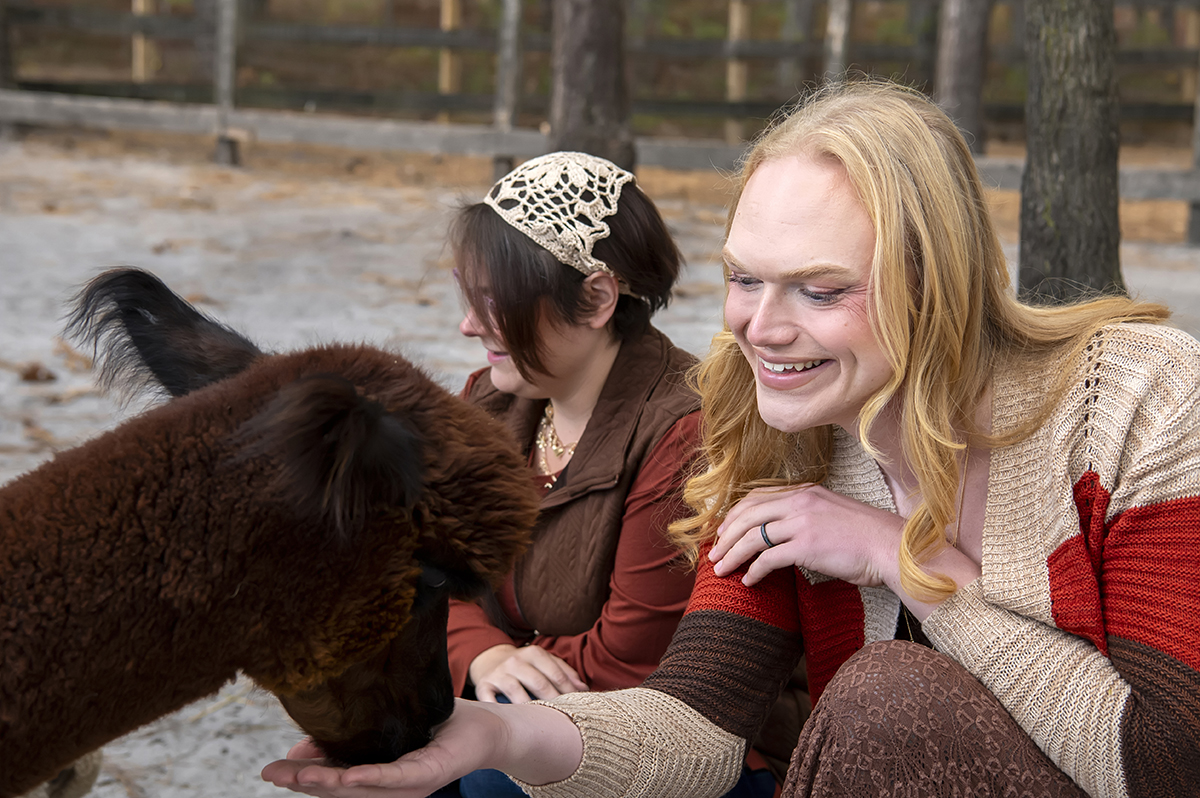same sex engaged couple at alpaca farm for fall engagement photos